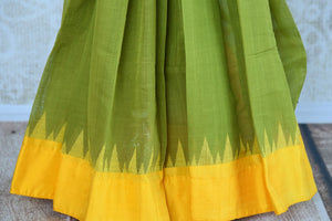 Buy green ikat khaddi sari online in USA with yellow border. Pure Elegance clothing store brings an alluring collection of ethnic Indian ikat saris in USA for women. -pleats