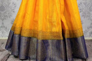 Shop yellow tussar Banarasi sari online in USA with blue border. Browse through a range of exclusive Indian handloom sarees in USA at Pure Elegance online store. -pleats