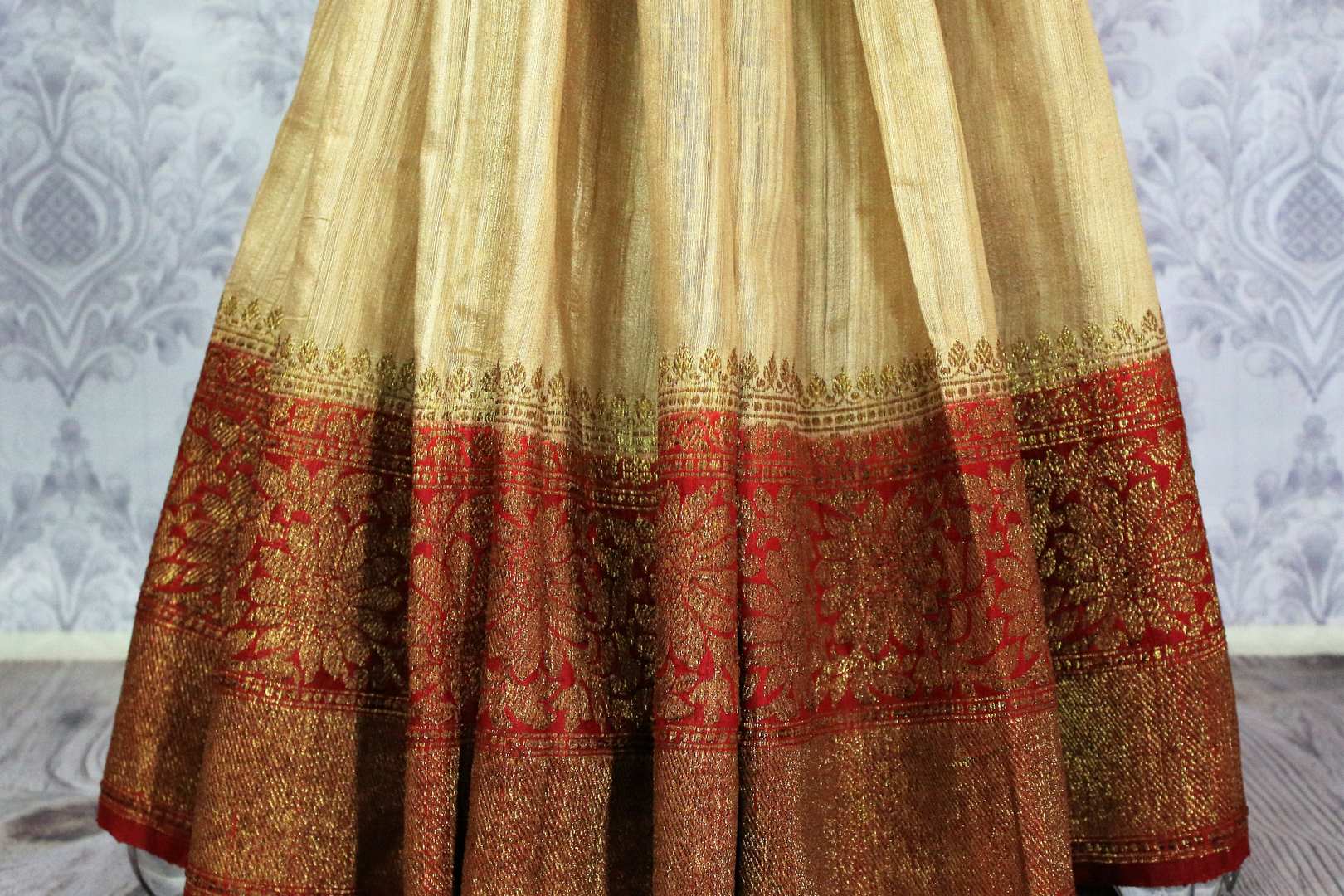 Buy beige tussar Banarasi saree online in USA with red border. Browse through a range of exclusive Indian handloom sarees in USA at Pure Elegance online store.-pleats