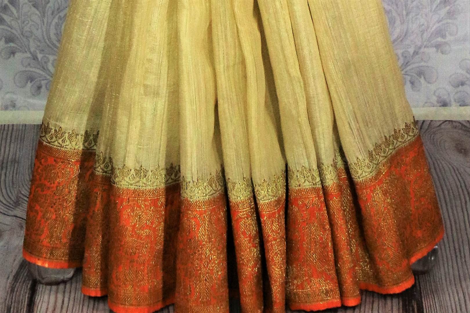 Buy cream Benarasi tussar saree online in USA with orange border. Browse through a range of traditional Indian sarees in USA at Pure Elegance online store. Shop now.-pleats