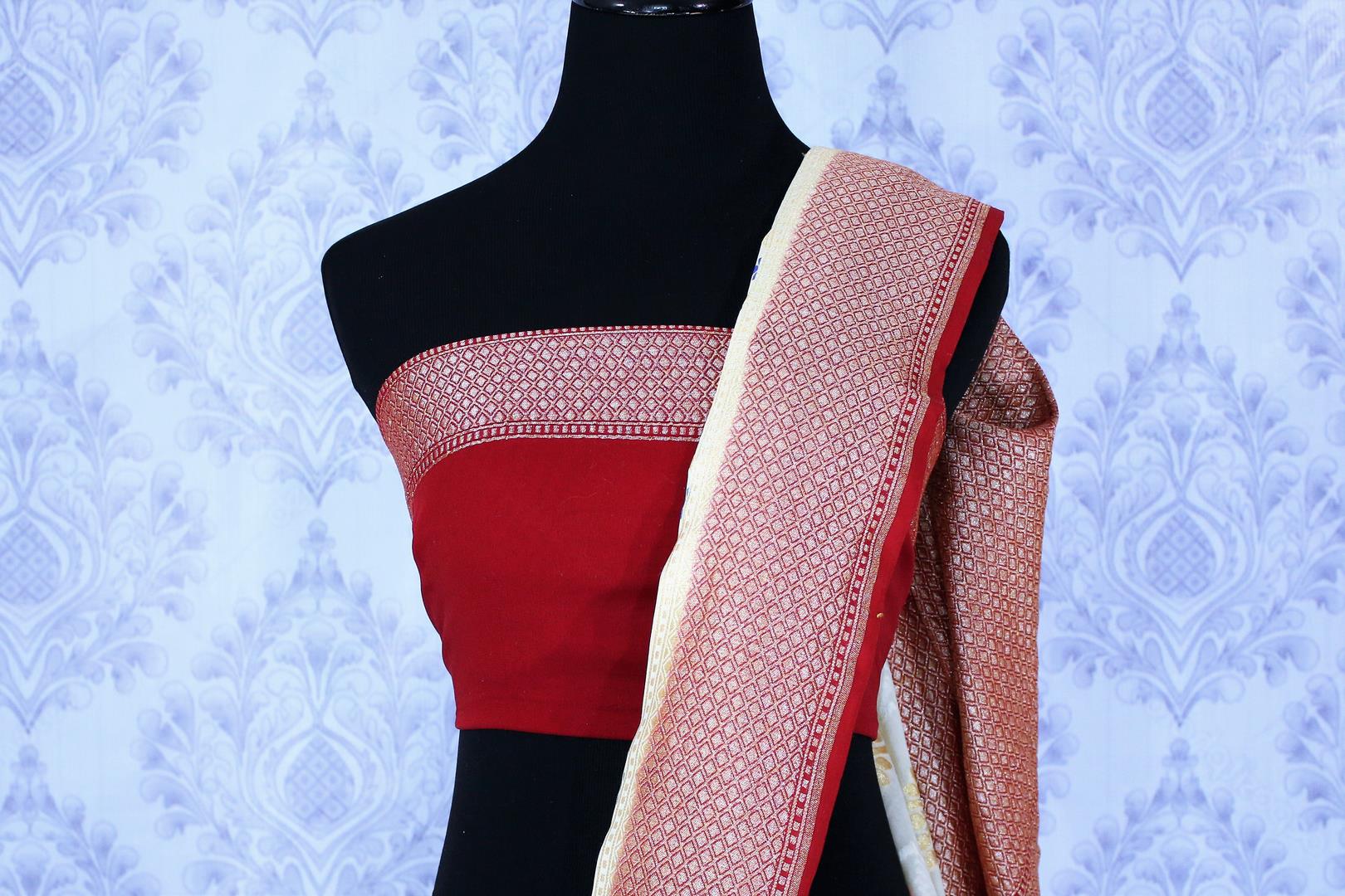 Buy cream georgette Banarasi saree online in USA. The alluring design of the saree with red zari border and minakari makes it perfect for a traditional festival look. Select from an exquisite collection of traditional Indian Banarasi sarees, designer saris at Pure Elegance clothing store or shop online.-blouse pallu