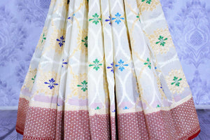 Buy cream georgette Banarasi saree online in USA. The alluring design of the saree with red zari border and minakari makes it perfect for a traditional festival look. Select from an exquisite collection of traditional Indian Banarasi sarees, designer saris at Pure Elegance clothing store or shop online.-pleats