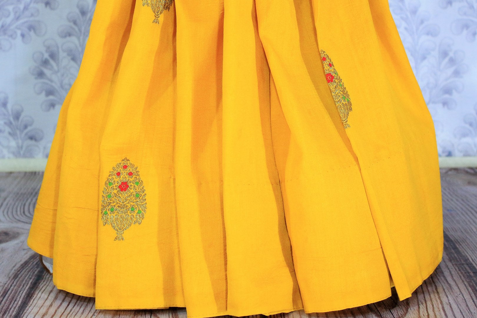 This yellow muga banarsi silk saree is totally stealing our heart away. The vibrant hued embroidered silk sari is perfect for festivities and weddings. Style this gorgeous sari with contrasting bright red designer blouse. Shop designer silk sarees, printed sarees, ikkat sari online or visit Pure Elegance store in USA.-pleats