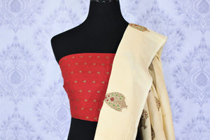 Embrace the uniqueness of this sartorial cream embroidered muga banarsi silk saree. Drape this traditional white and red Indian silk sari to weddings and festivities with a striking red buta work blouse. Shop designer silk sarees, ikkat saris, printed sarees online or visit Pure Elegance store, USA. -blouse pallu