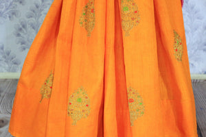 Escalate your style game with this exquisitely designed orange embroidered muga banarsi silk sari. Pair this stunning saree with pink raw silk and embroidered blouse complemented with purple border and embroidery. Shop designer silk sarees, printed saris, banarsi saris online or visit Pure Elegance store in USA. -pleats