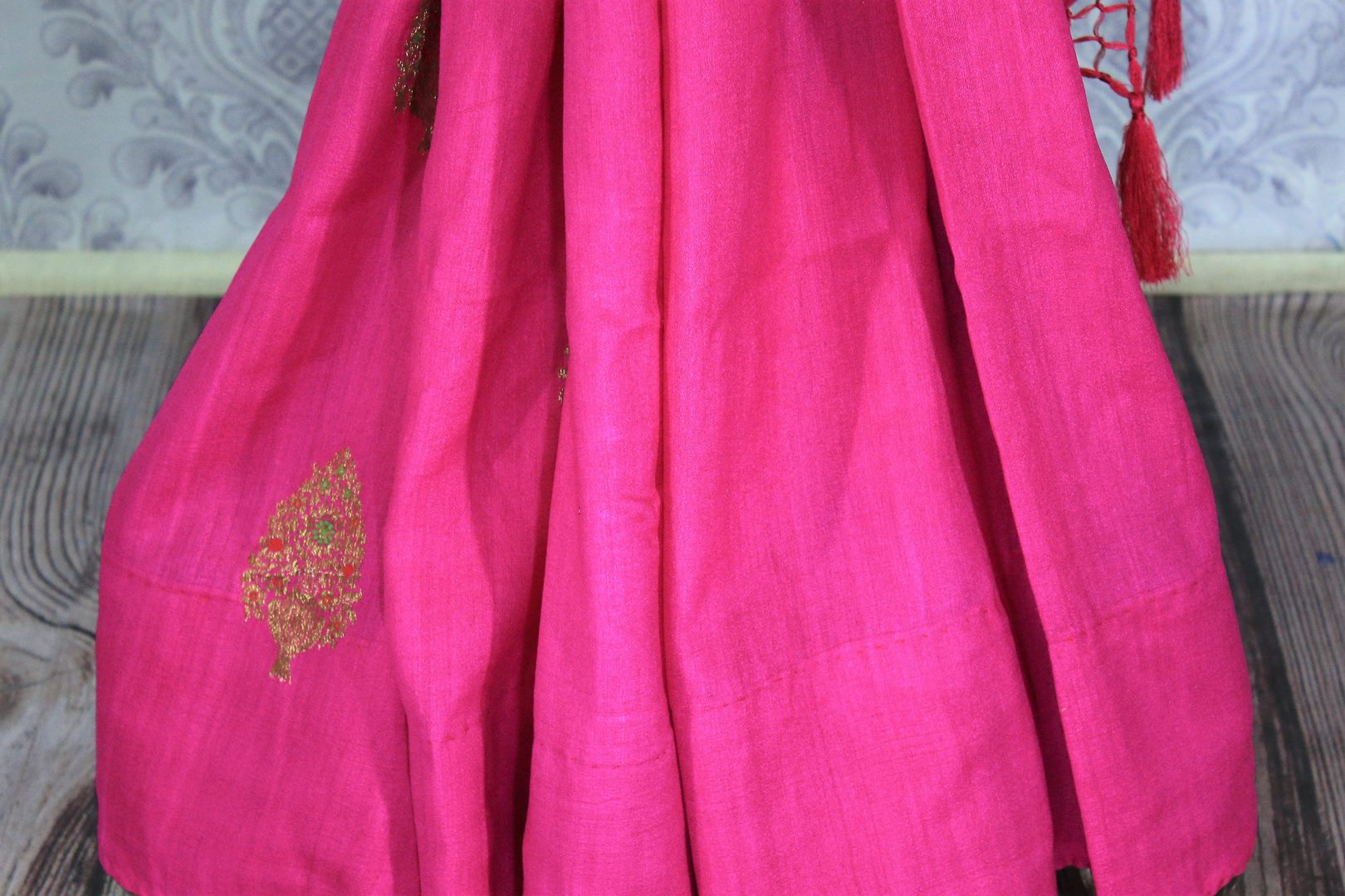 Be the showstopper in this exquisitely designed bright pink embroidered muga banarsi silk sari with zari detailing. Style this vibrant sari with a magenta blouse and  the heavily embroidered pallu for weddings or parties. Shop printed silk sarees, crepe silk saris, ikkat sarees online or visit Pure Elegance store in USA. -pleats
