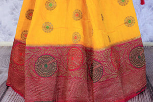 Your perfect wedding ensemble in traditional yellow and red combination with zari detailing is oh so dreamy. Indulge in this breath-taking muga banarsi silk saree complemented with a heavy woven red pallu and designer red blouse. Shop designer silk sarees, ikkat sarees online or visit Pure Elegance store in USA.-pleats