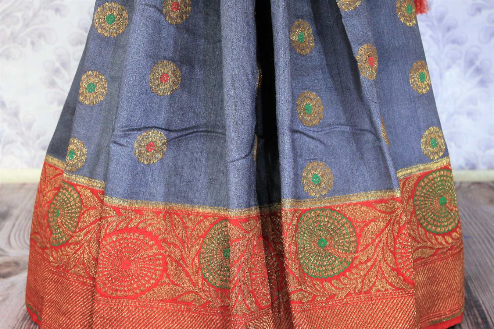 Relish the exquisite wedding ensemble with this grey and red combination of muga banarsi silk saree. The zari border complemented with a stunning red embroidered designer blouse and a heavily woven red zari pallu is such an eye-catcher. Shop designer silk saris,printed sarees online or visit Pure Elegance store in USA.-pleats