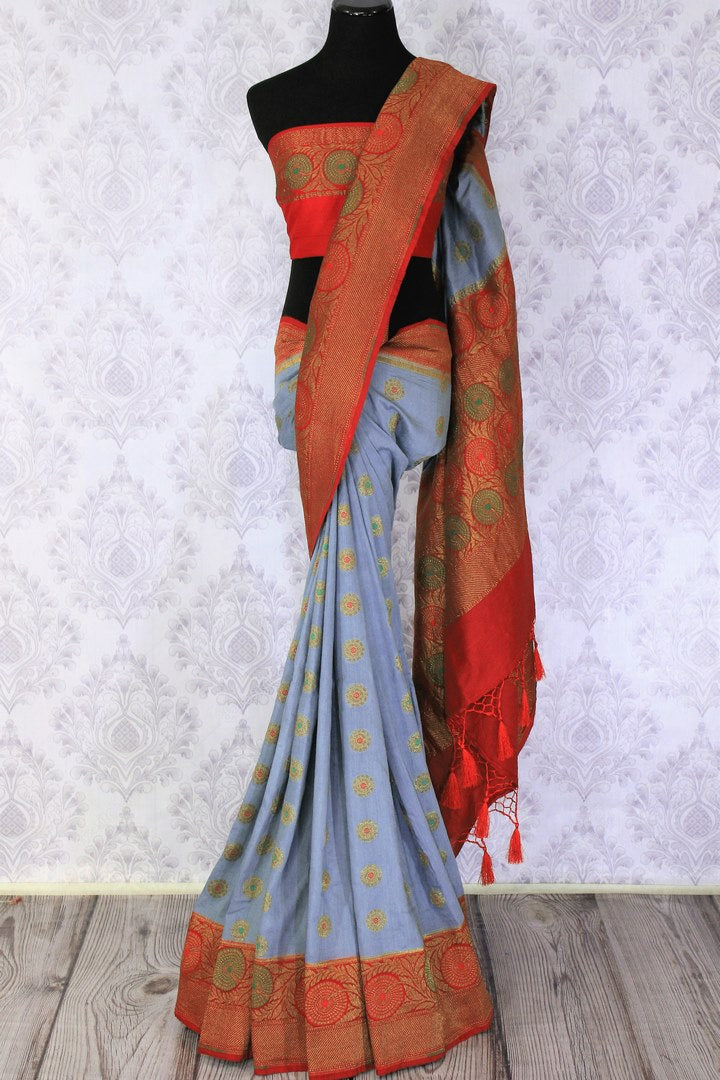 Generously tailored for women with substance, this grey designer muga banarsi silk saree is perfect for weddings and festivities. It comes with a zari border and contrasting red designer blouse and a woven pallu. Shop designer silk saris, ikkat sarees, printed saris online or visit Pure Elegance store in USA. -full view