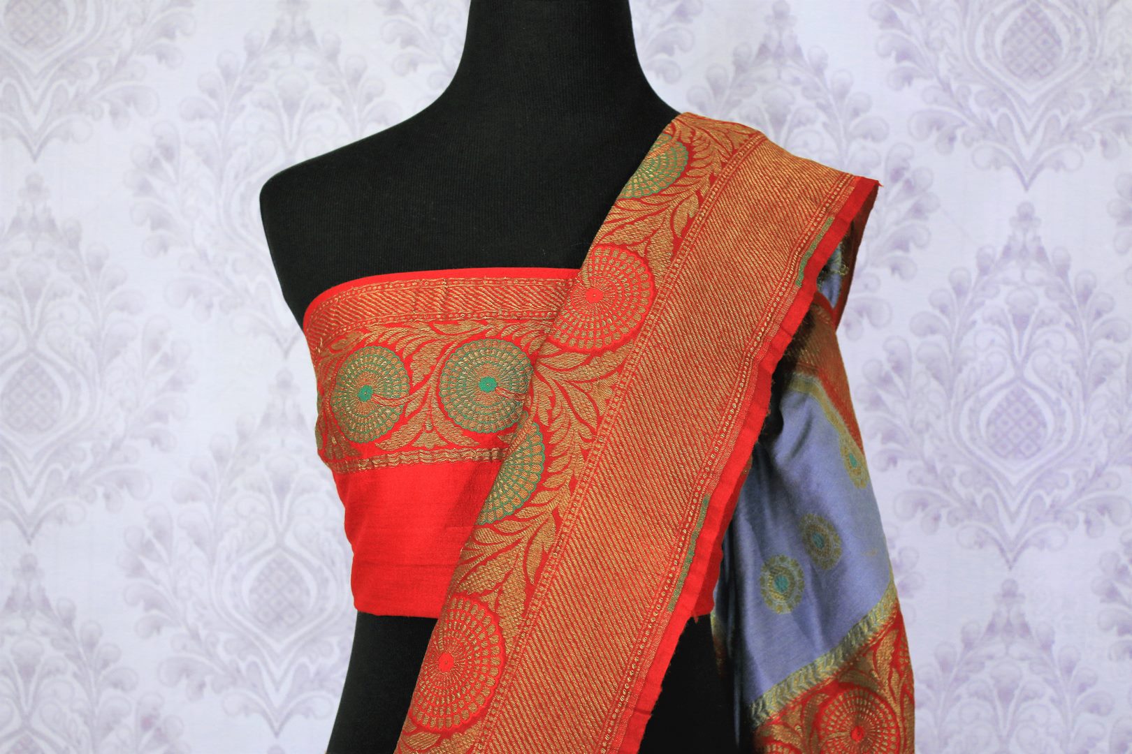 Generously tailored for women with substance, this grey designer muga banarsi silk saree is perfect for weddings and festivities. It comes with a zari border and contrasting red designer blouse and a woven pallu. Shop designer silk saris, ikkat sarees, printed saris online or visit Pure Elegance store in USA. -blouse pallu