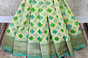 Add oodles of poise to your look with our green georgette banarsi silk saree. It comes with a graceful zari border and handwoven motifs all over. Style it with a soft green zari embroidered blouse to up your style game. Shop such designer silk sari online or visit Pure Elegance store, USA.-pleats