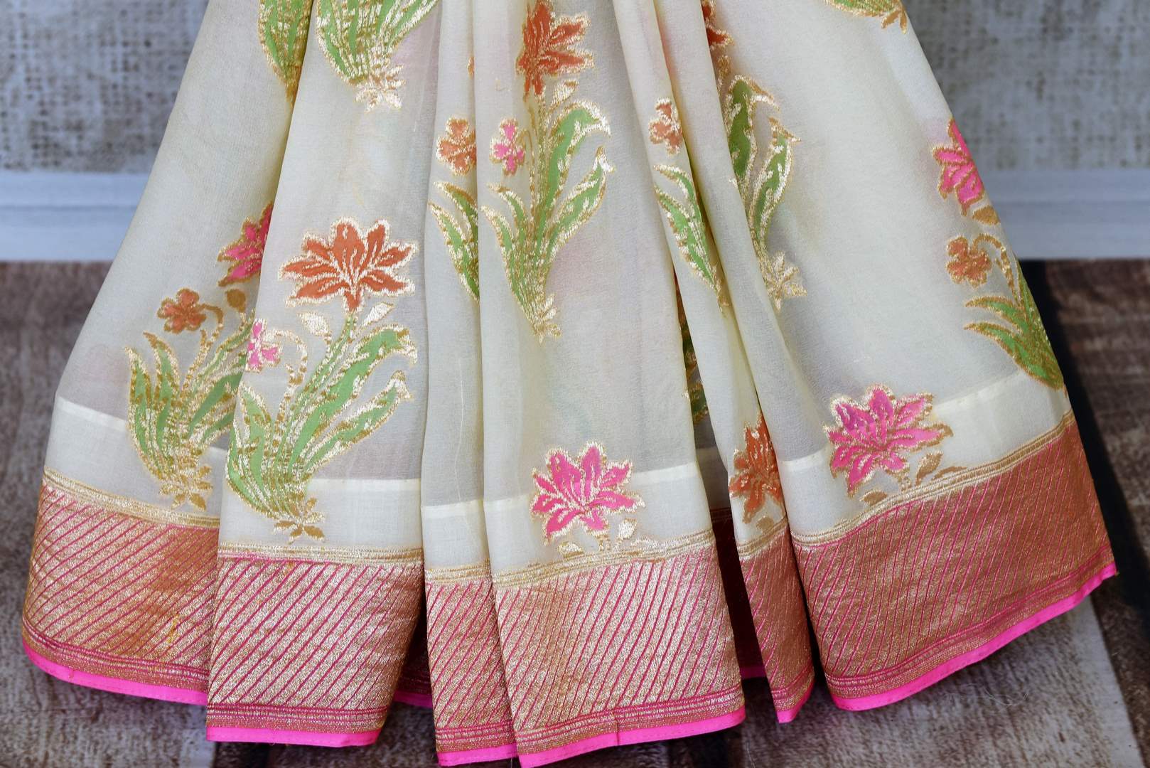 Strike a lasting impression in our white georgette banarasi silk saree. It has a gorgeous zari border accompanied with an equally stunning white zari blouse. Style it for social events, soirees and family gatherings. Shop such designer printed sari, embroidery saree online or visit Pure Elegance store, USA.-pleats