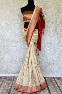 Treat yourself with this suave white khaddi banarsi silk saree paired with a stunning designer red blouse. Featuring zari work on the saree, and intricate buta work, it looks spectacular. Shop such designer silk sarees, printed sari, embroidery saree online or visit Pure Elegance store, USA.-full view