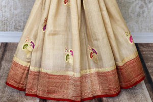 Treat yourself with this suave white khaddi banarsi silk saree paired with a stunning designer red blouse. Featuring zari work on the saree, and intricate buta work, it looks spectacular. Shop such designer silk sarees, printed sari, embroidery saree online or visit Pure Elegance store, USA.-pleats