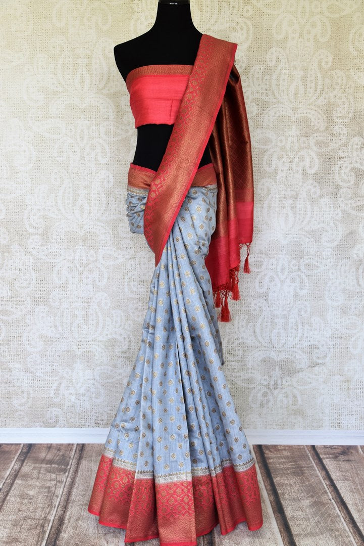 Satiate your dreamy appetite with this stunning grey tussar banarsi silk saree. It comes with a gold zari detailing on the deep red handwoven border. Style this saree with a pretty contrasting red blouse to make quite a statement. Shop designer embroidered sari online or visit Pure Elegance store, USA.-full view