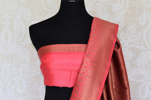 Satiate your dreamy appetite with this stunning grey tussar banarsi silk saree. It comes with a gold zari detailing on the deep red handwoven border. Style this saree with a pretty contrasting red blouse to make quite a statement. Shop designer embroidered sari online or visit Pure Elegance store, USA.-blouse pallu