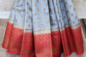 Satiate your dreamy appetite with this stunning grey tussar banarsi silk saree. It comes with a gold zari detailing on the deep red handwoven border. Style this saree with a pretty contrasting red blouse to make quite a statement. Shop designer embroidered sari online or visit Pure Elegance store, USA.-pleats