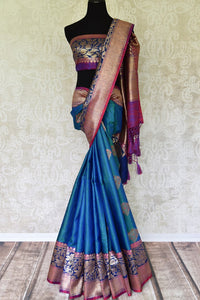 Indulge in the ethereal beauty of this royal blue tussar banarsi silk saree which comes with buta work and zari border. Style it with a designer blouse and steal the limelight as you sashay in a heavily embroidered pallu. Shop handloom sarees, georgette sari, ikkat saree online or visit Pure Elegance store, USA. -full view
