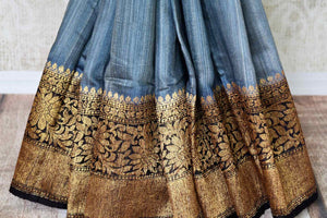 Channel sophistication in grey matka banarsi silk saree. A perfect pick for festivities and formal events, style this saree with a contrasting black and gold zari woven blouse. The gold zari border flows throughout the sari. Shop banarsi silk sarees, linen sari, georgette saree online or visit Pure Elegance store, USA.-pleats