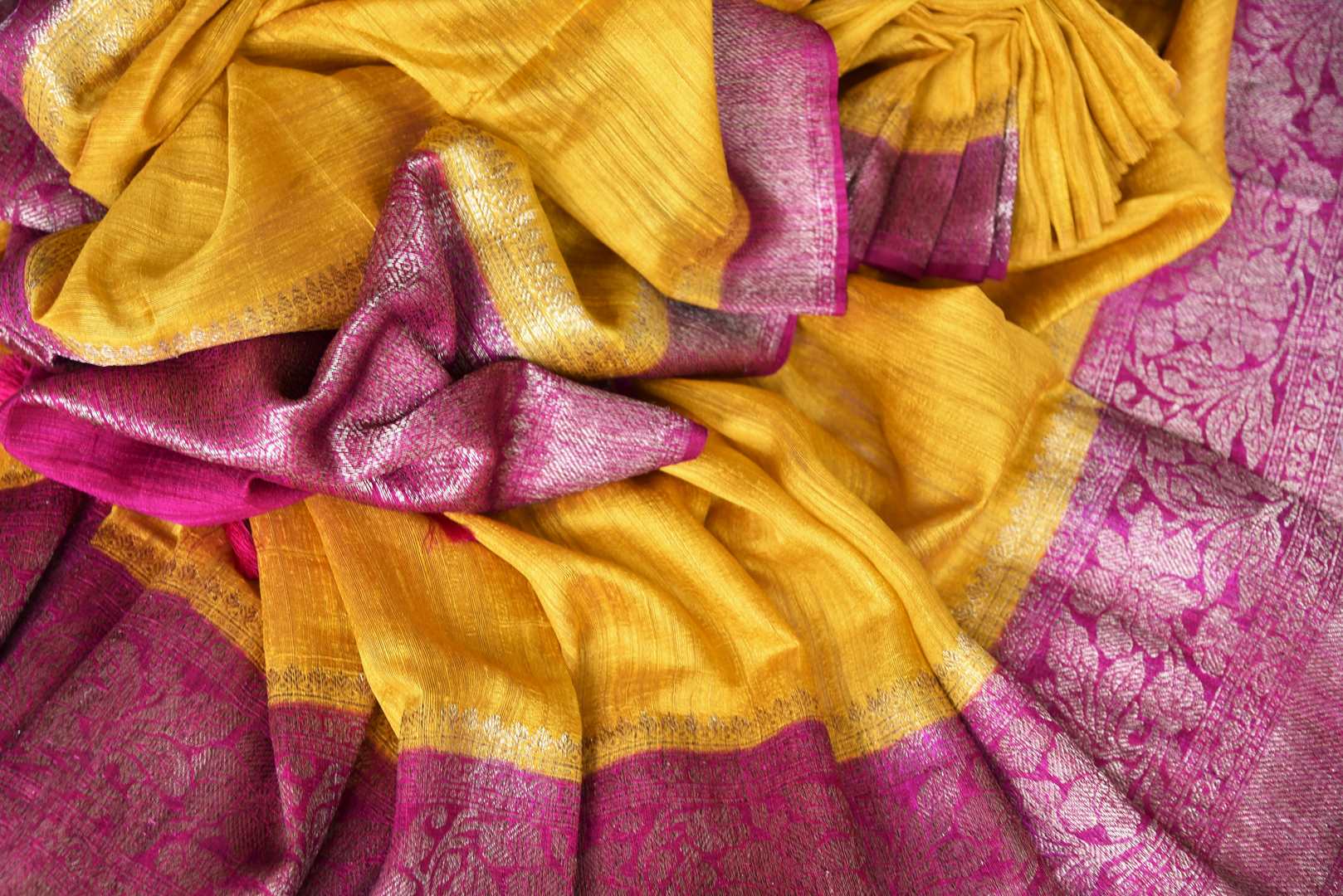 Shine bright like a sunshine in our vibrant yellow matka banarsi silk sari which is blended well with a pink zari border. Style this effervescent saree with a hot pink zari blouse to catch the fancy of folks around. Shop designer silk sarees, georgette sari, organza sari online or visit Pure Elegance store, USA.-details