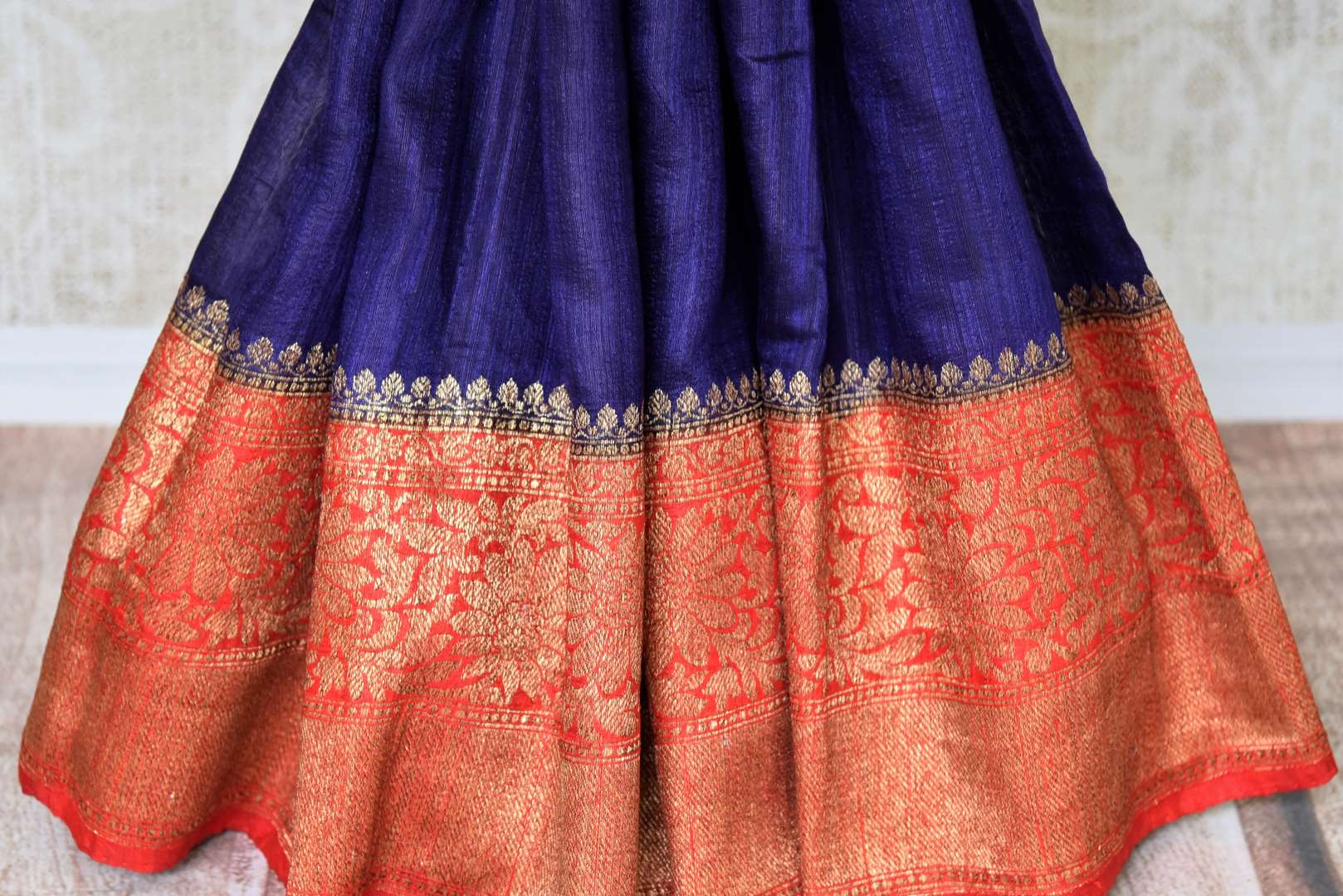 Up your stylish appeal in this royal blue matka banarsi silk saree with a graceful red zari border. Style this saree with a stunning bright red zari designer blouse complemented with a heavily woven pallu. Shop handloom sarees, linen sari, chiffon saree online or visit Pure Elegance store, USA.-pleats