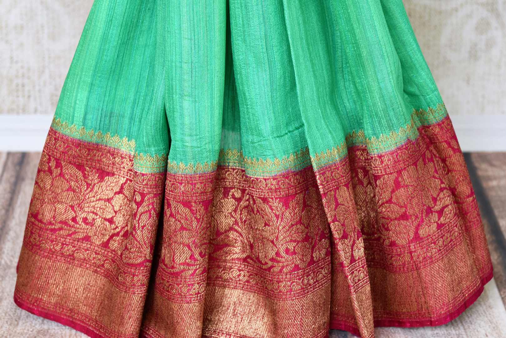 Leave them enthralled as you step up your style game in this mint green matka banarsi silk saree with a stunning red zari border. Elevate your look with a contrasting red zari designer blouse and heavily woven pallu. Shop designer silk sarees, embroidered sari, kalamkari sari online or visit Pure Elegance store, USA.-pleats
