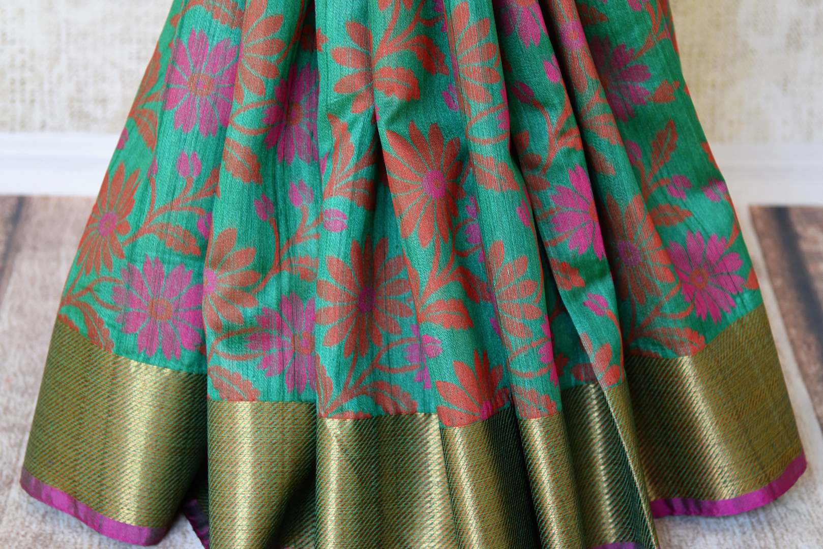 Buy green floral tussar Banarasi saree with zari border online in USA. Adorn yourself in glorious Indian sarees from Pure Elegance Indian clothing store in USA. We have an exclusive range of Indian designer sarees, traditional handloom saris, Banarasi sarees to make your Indian look absolutely captivating.-pleats
