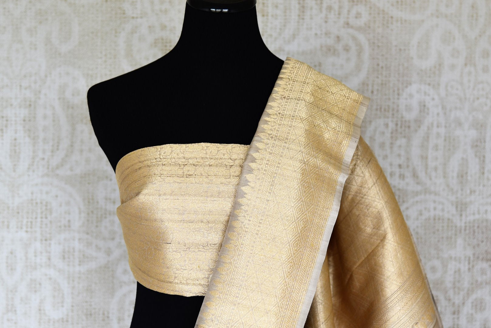Shop beige tussar Banarasi saree online in USA with floral minakari zari buta. Shop more such exquisite Indian saris in USA from Pure Elegance. Get floored by a range of designer sarees, pure silk sarees, Kanchipuram silk saris at our Indian fashion store in USA.-blouse pallu