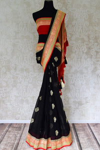 Buy stunning black georgette Benarasi saree online in USA with red floral zari border from Pure Elegance online store. Visit our exclusive Indian clothing store in USA and get floored by a range of exquisite pure handloom sarees, Banarasi sarees, silk sarees, Indian jewelry and much more to complete your ethnic look.-full view