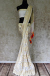 Buy off-white Banarasi georgette saree online in USA with overall zari work from Pure Elegance online store. Visit our exclusive Indian clothing store in USA and get floored by a range of exquisite Indian Kanjivaram saris, Banarasi sarees, silk sarees, Indian jewelry and much more to complete your ethnic look.-full view