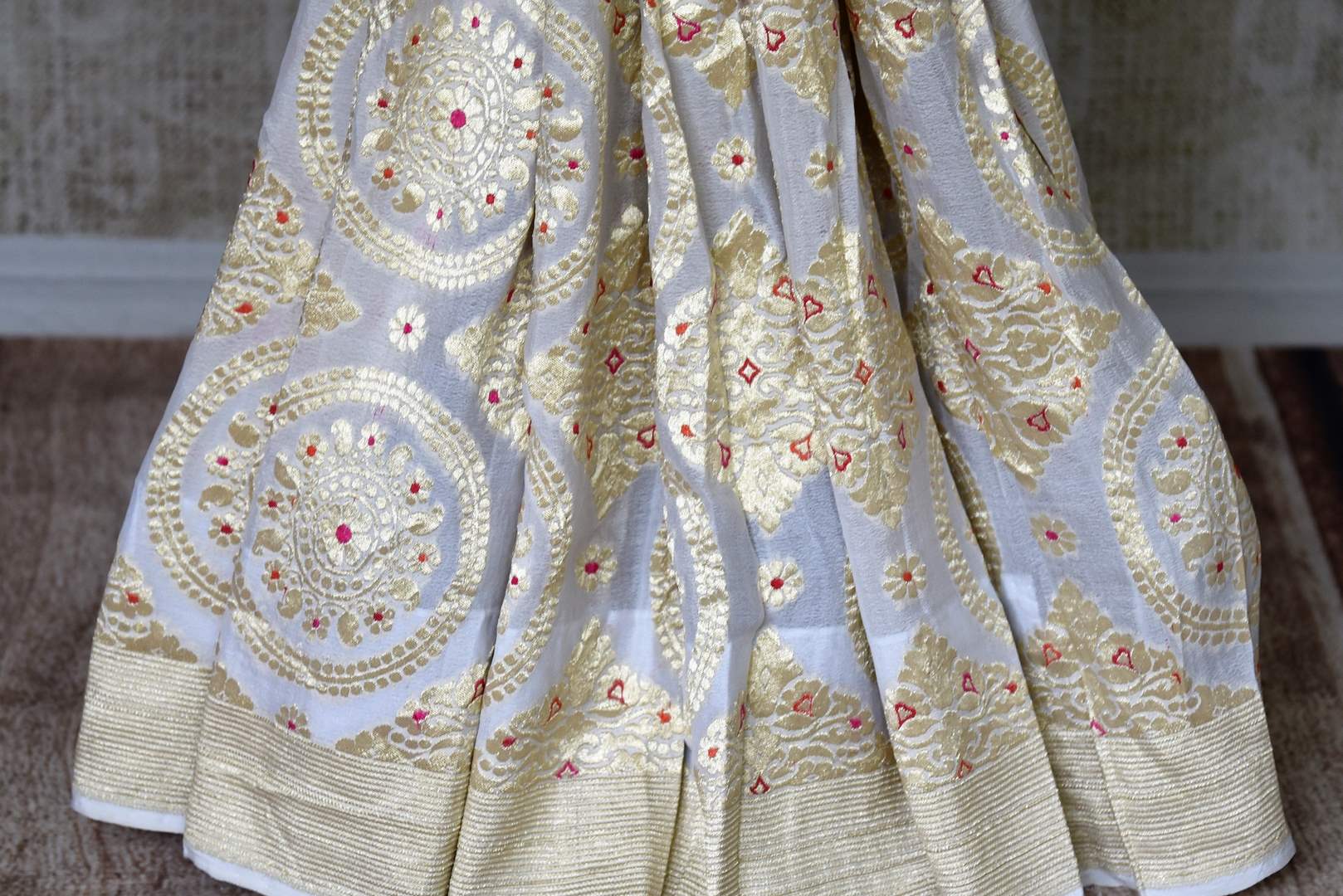 Buy off-white Banarasi georgette saree online in USA with overall zari work from Pure Elegance online store. Visit our exclusive Indian clothing store in USA and get floored by a range of exquisite Indian Kanjivaram saris, Banarasi sarees, silk sarees, Indian jewelry and much more to complete your ethnic look.-pleats