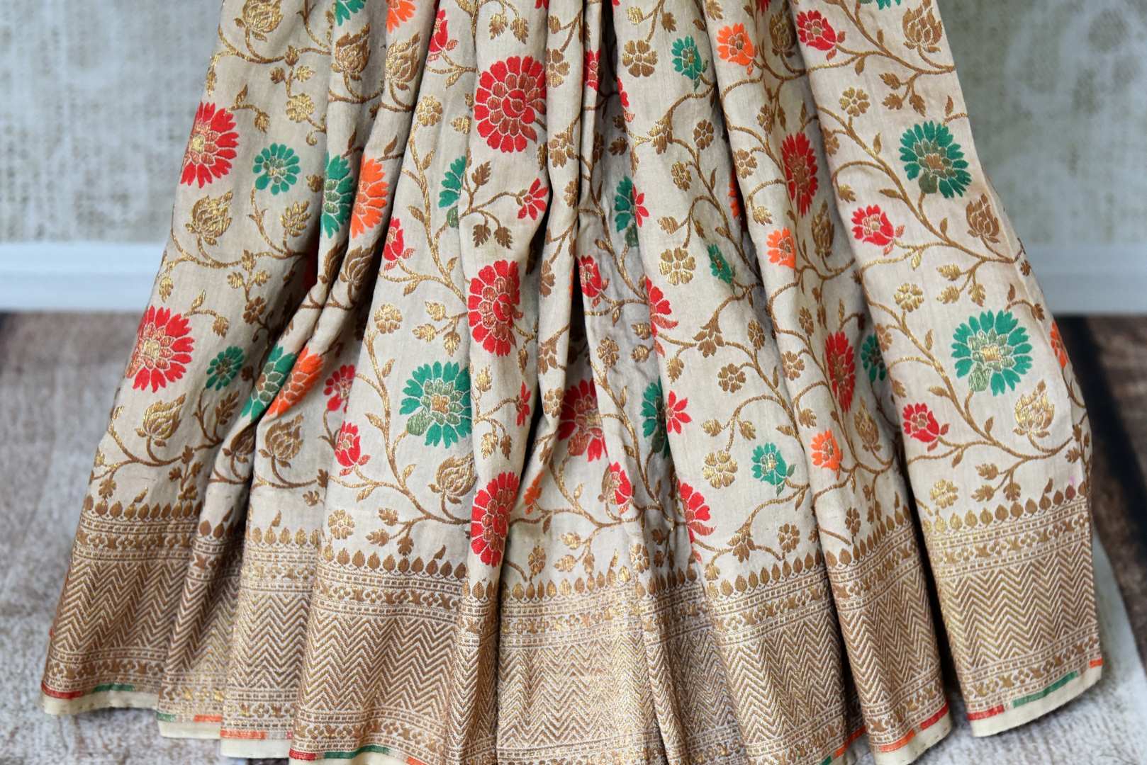 Buy beige muga Banarasi saree online in USA with zari and minakari work from Pure Elegance online store. Visit our exclusive Indian clothing store in USA and get floored by a range of exquisite pure handloom sarees, Banarasi sarees, silk sarees, Indian jewelry and much more to complete your ethnic look.-pleats