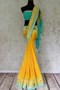 Shop yellow Banarasi georgette saree online in USA with floral zari border from Pure Elegance online store. Visit our exclusive Indian fashion store in USA and get floored by a range of exquisite pure handloom sarees, Banarasi sarees, silk sarees, Indian jewelry and much more to complete your ethnic look.-full view