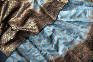 Shop grey muga tussar saree online in USA with zari buta and black zari border from Pure Elegance. Choose from a range of exquisite Indian designer saris, Banarasi sarees, pure silk sarees in beautiful styles and designs from our Indian fashion store in USA and flaunt your tasteful sartorial choices on special occasions.-details