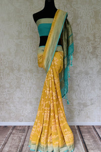 Buy yellow Banarasi georgette saree online in USA with blue zari border. Find a splendid collection of Indian designer sarees with blouses in USA at Pure Elegance Indian clothing store. Make a striking appearance on festive occasions by shopping from a range of pure silk saris, Banarasi sarees, embroidered saris from our online store.-full view