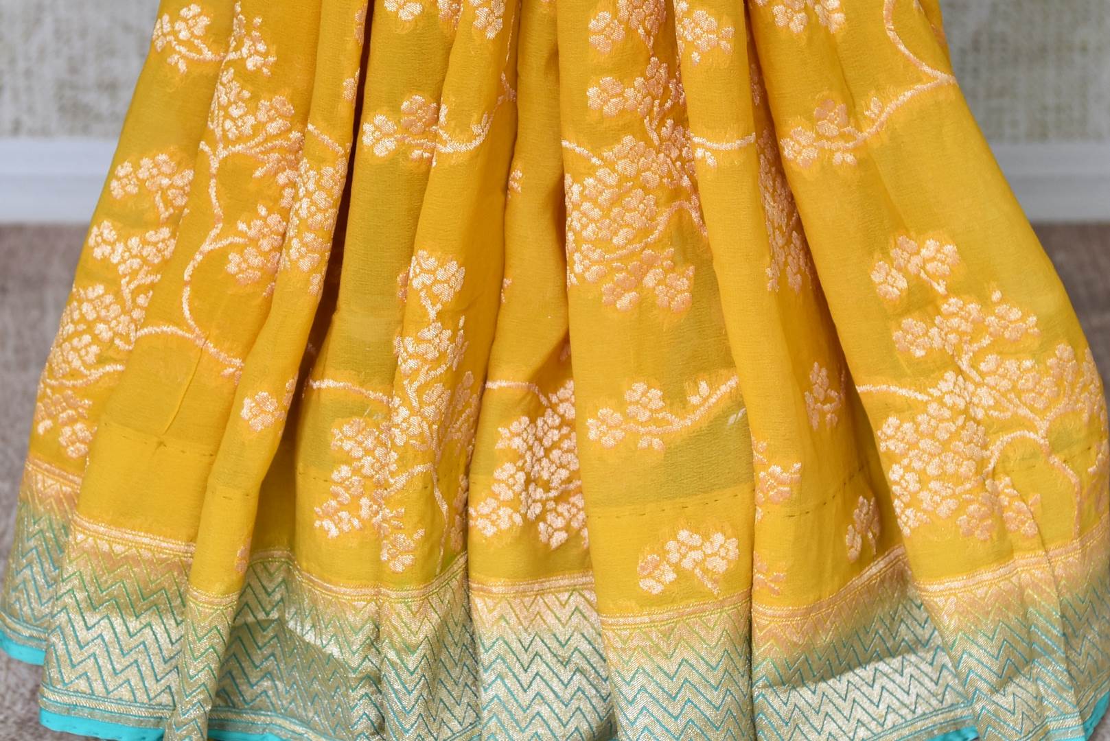 Buy yellow Banarasi georgette saree online in USA with blue zari border. Find a splendid collection of Indian designer sarees with blouses in USA at Pure Elegance Indian clothing store. Make a striking appearance on festive occasions by shopping from a range of pure silk saris, Banarasi sarees, embroidered saris from our online store.-pleats