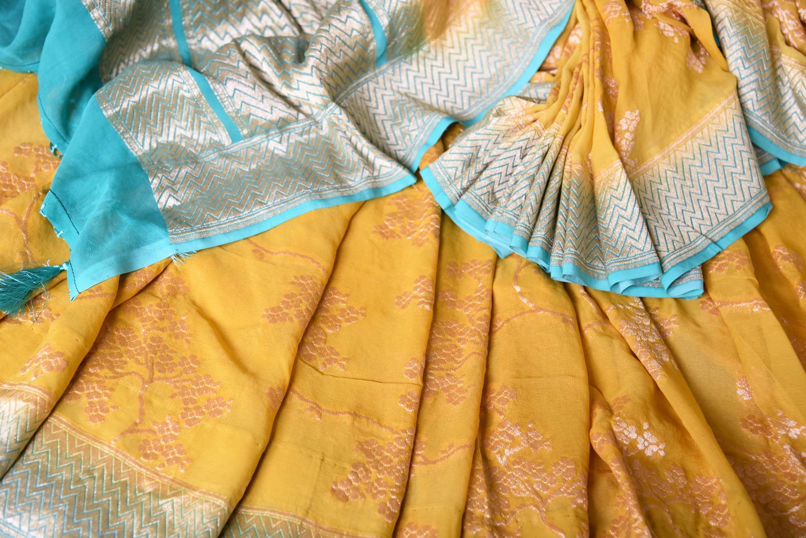 Buy yellow Banarasi georgette saree online in USA with blue zari border. Find a splendid collection of Indian designer sarees with blouses in USA at Pure Elegance Indian clothing store. Make a striking appearance on festive occasions by shopping from a range of pure silk saris, Banarasi sarees, embroidered saris from our online store.-details