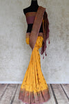 Buy yellow muga Benarasi sari online in USA with purple antique zari border. Shine bright on special occasions with traditional Indian sarees, Banarasi sarees, pure silk sarees in rich colors and designs from Pure Elegance Indian fashion store in USA.-full view