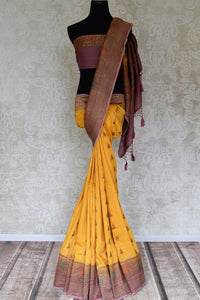 Buy yellow muga Benarasi sari online in USA with purple antique zari border. Shine bright on special occasions with traditional Indian sarees, Banarasi sarees, pure silk sarees in rich colors and designs from Pure Elegance Indian fashion store in USA.-full view