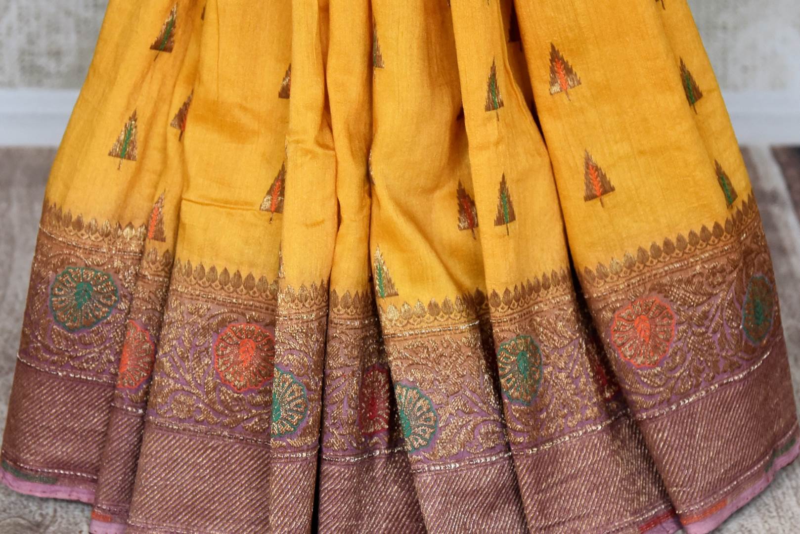 Buy yellow muga Benarasi sari online in USA with purple antique zari border. Shine bright on special occasions with traditional Indian sarees, Banarasi sarees, pure silk sarees in rich colors and designs from Pure Elegance Indian fashion store in USA.-pleats