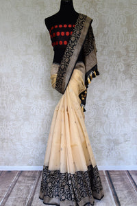 Shop cream organza Banarasi saree online in USA with black floral zari birder. Get festival ready with a range of exquisite handcrafted Indian sarees, traditional Banarasi sarees, silk sarees from Pure Elegance Indian clothing store in USA.-full view