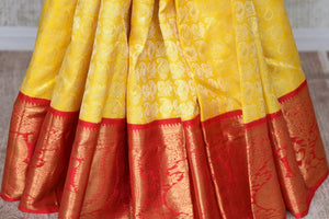 Buy yellow Kanchipuram silk sari with red zari border online in USA from Pure Elegance. Make your ethnic style perfect with a range of exquisite Indian designer saris with blouses, embroidered sarees, pure handloom sarees available at our exclusive Indian fashion store in USA and also on our online store. Shop now.-pleats