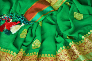 Shop green georgette Banarasi sari online in USA with floral zari buta and foliate zari border. Elevate your traditional saree style with beautiful Indian Banarasi saris from Pure Elegance Indian fashion store in USA. We also have a stunning variety of bridal saris for Indian brides in USA. Shop now.-details