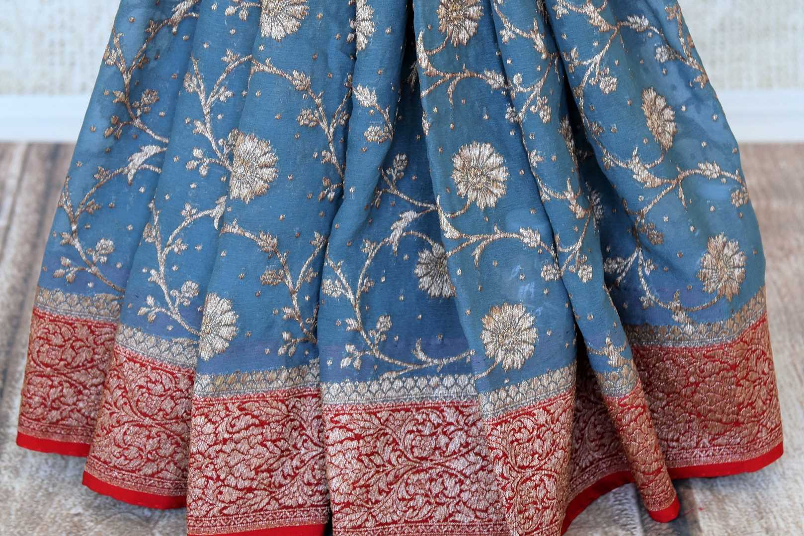 Buy blue georgette Banarasi sari online in USA with red zari border. Feel traditional on special occasions in beautiful Indian designer saris from Pure Elegance Indian fashion store in USA. Choose from a splendid variety of Banarasi sarees, pure handwoven saris. Buy online.-pleats