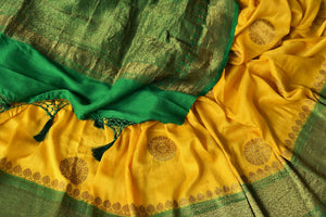 Buy yellow muga Banarasi saree online in USA with green antique zari border. Be an epitome of elegance in exquisite Banarasi sarees from Pure Elegance Indian clothing store in USA.-details