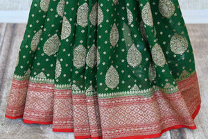 Shop green georgette Banarasi sari online in USA with red zari border. Feel traditional on special occasions in beautiful Indian designer saris from Pure Elegance Indian fashion store in USA. Choose from a splendid variety of Banarasi sarees, pure handwoven saris. Buy online.-pleats