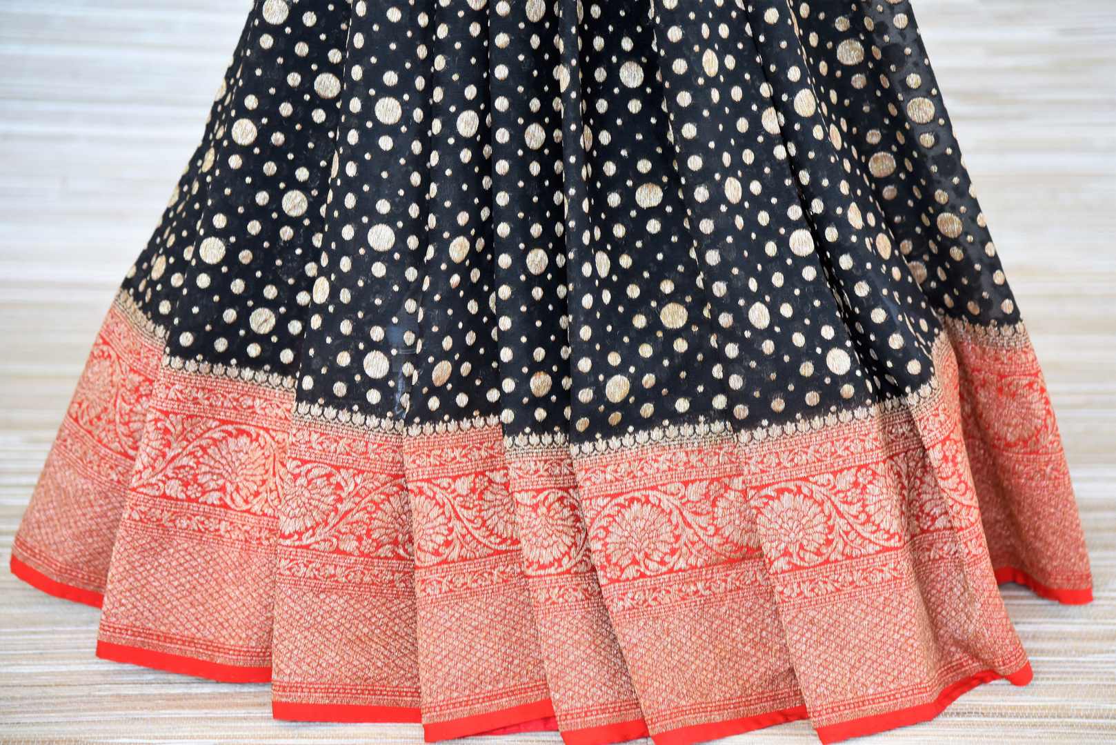 Shop black georgette Banarasi sari online in USA with red zari border. Make your ethnic wardrobe colorful and rich with a splendid collection of Banarasi sarees from Pure Elegance Indian clothing store in USA. Shop online.-pleats