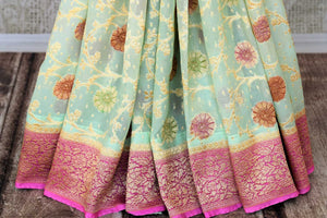 Shop pista green georgette Banarasi saree online in USA with pink zari border. Feel traditional on special occasions in beautiful Indian designer saris from Pure Elegance Indian fashion store in USA. Choose from a splendid variety of Banarasi sarees, pure handwoven saris. Buy online.-pleats
