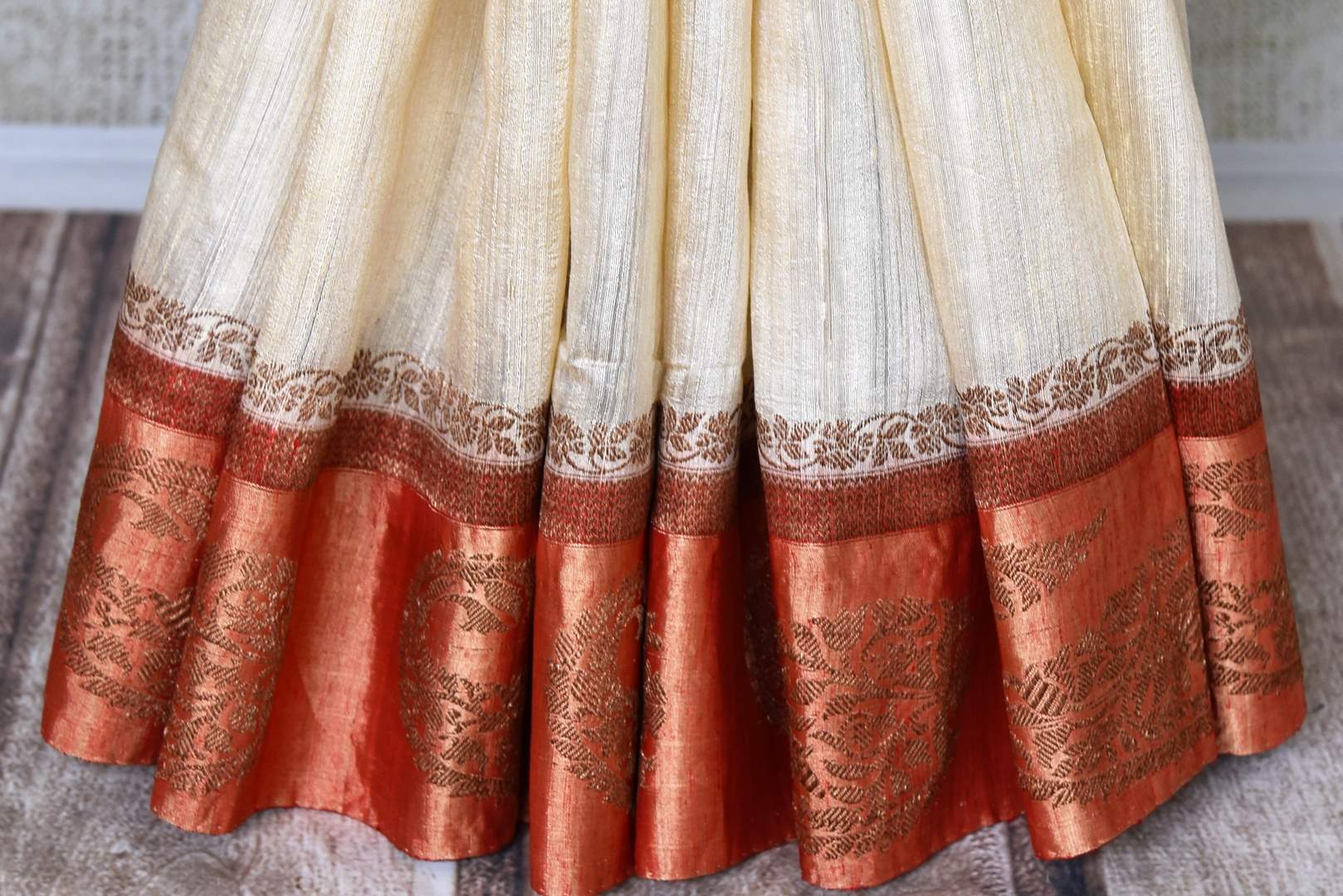 Shop traditional off-white tussar Benarasi saree online in USA with red golden zari border. Be an epitome of elegance in exquisite Banarasi saris from Pure Elegance Indian clothing store in USA.-pleats