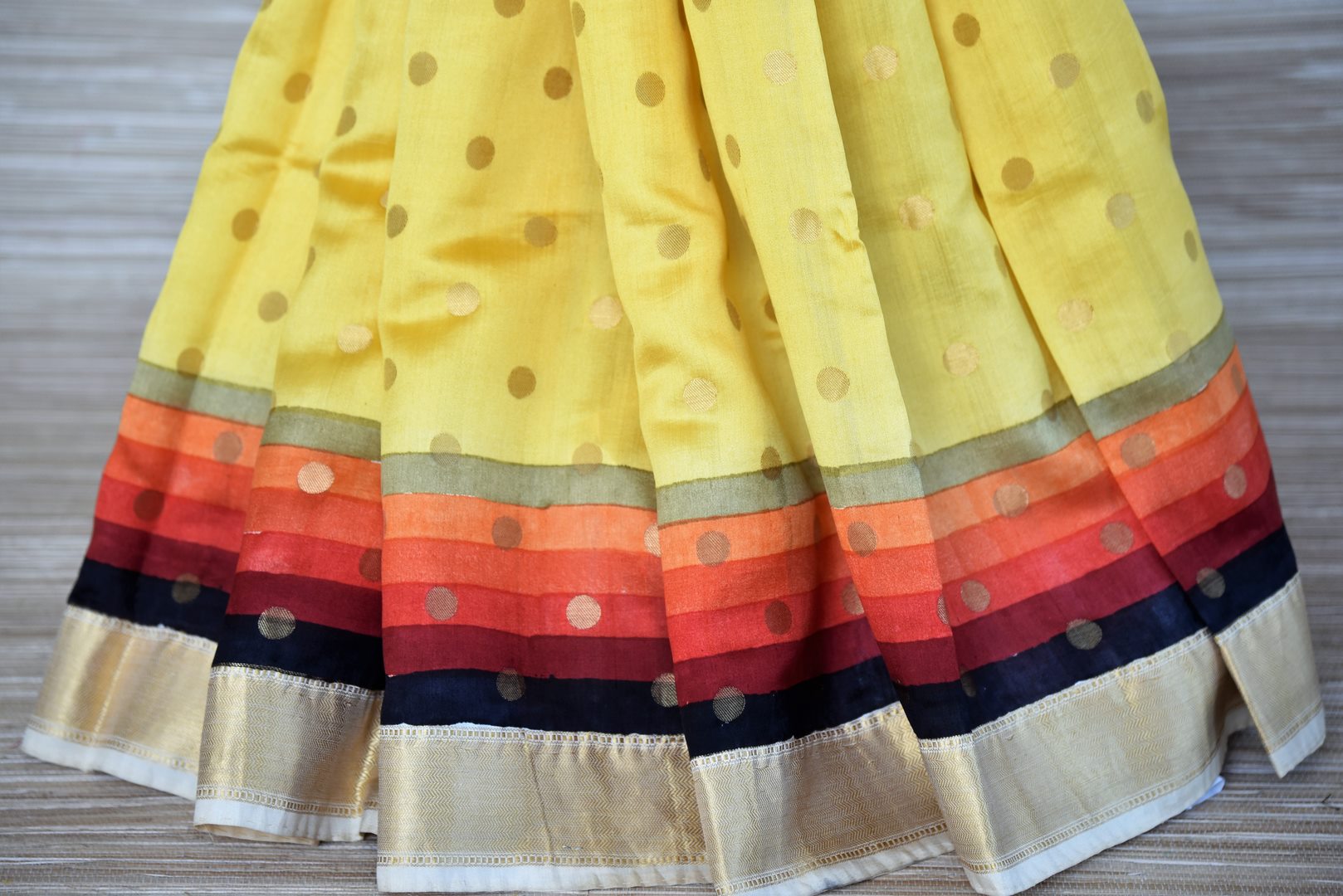 Shop bright yellow zari buta muga silk sari online in USA with multicolor zari border. Stand amongst the crowd with your tasteful ethnic style in beautiful handwoven silk sarees from Pure Elegance Indian fashion store for Indian women in USA.-pleat